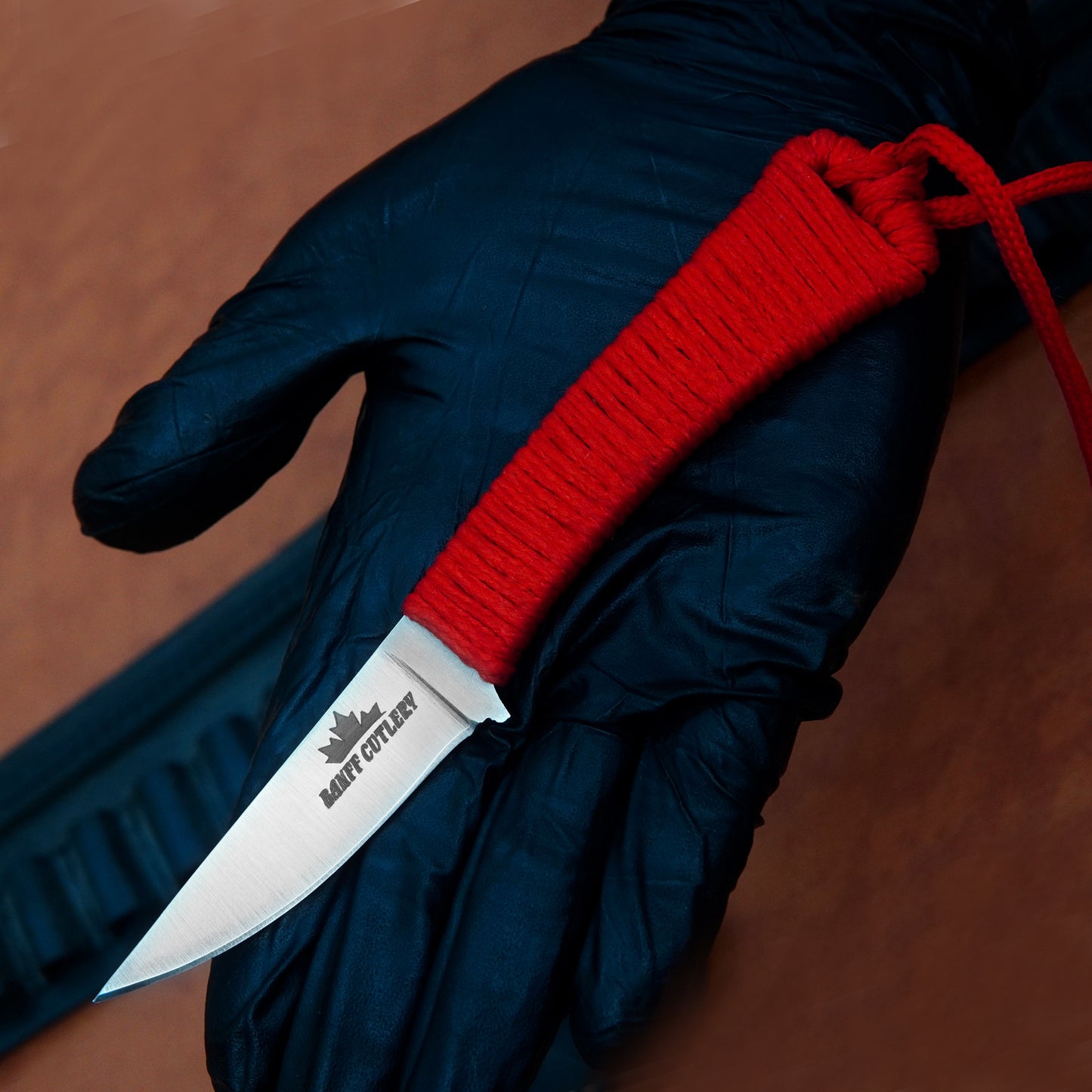 Durable multi-purpose tactical knife with D2 steel blade, paracord handle, and leather sheath, perfect for hunting and camping.
