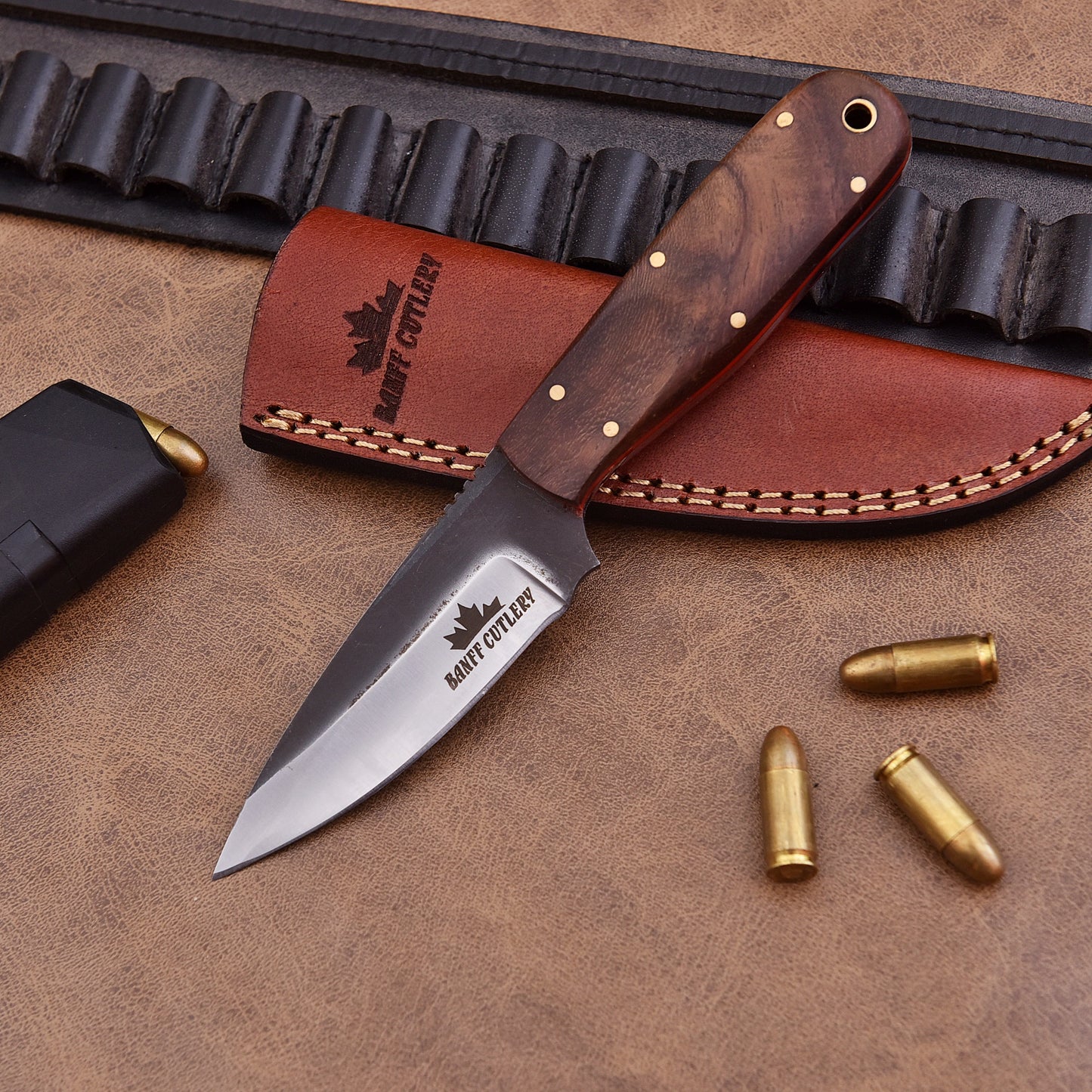 The Pathfinder Knife in a leather sheath, ideal for carrying in the wild during outdoor adventures.