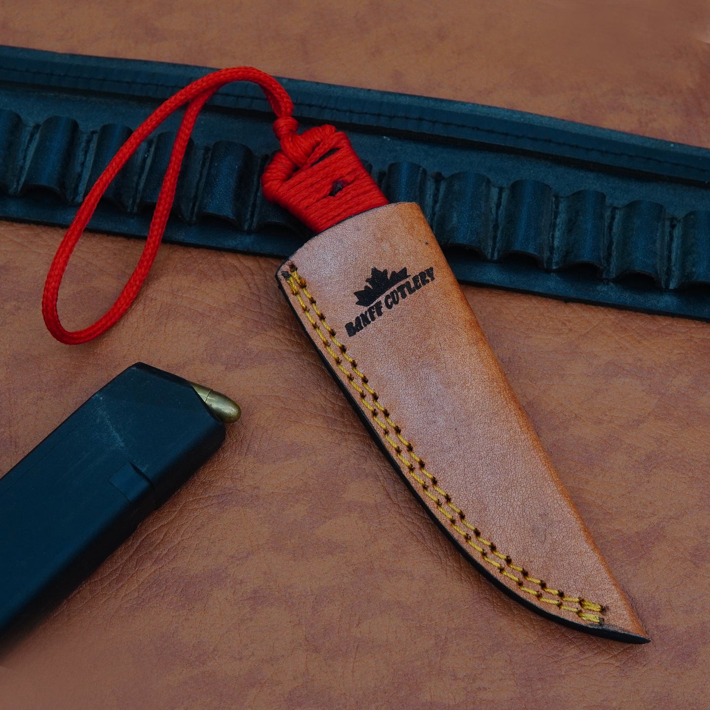 Versatile utility knife with razor-sharp D2 steel blade, ergonomic paracord handle, and leather sheath for skinning and outdoor tasks.