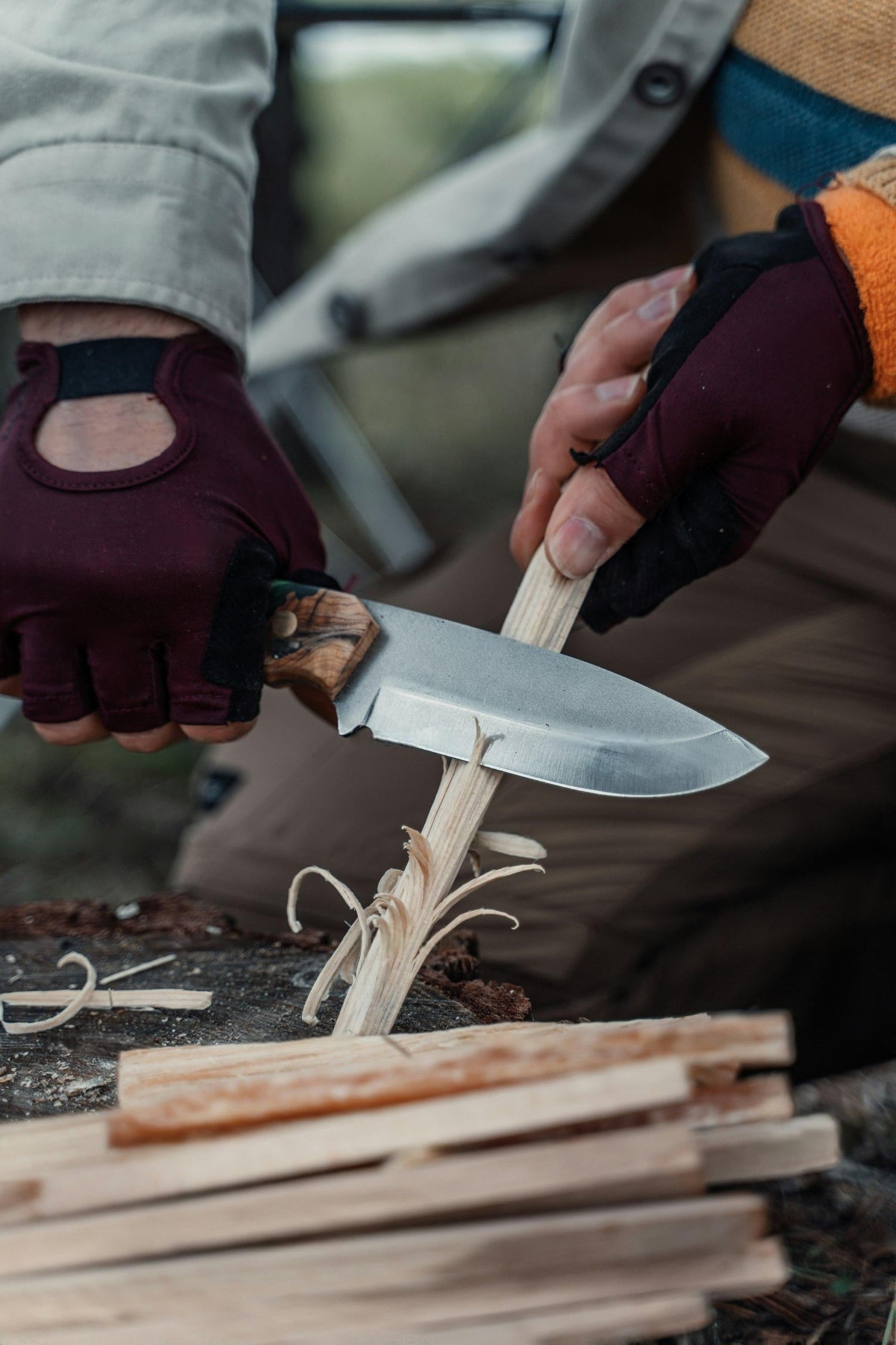 Outdoor survival knife carving wood for bushcraft and camping – full tang fixed blade knife with wooden handle in action.