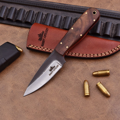 The Pathfinder Knife in a leather sheath, ideal for carrying in the wild during outdoor adventures.